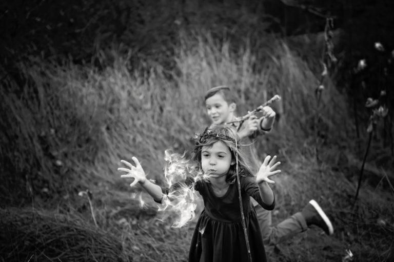 photo of children running and blowing dandelions